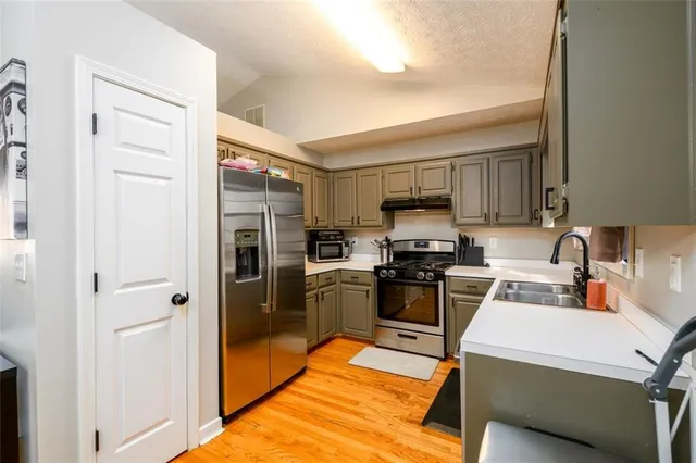 a kitchen with a refrigerator a stove top oven a sink and dishwasher