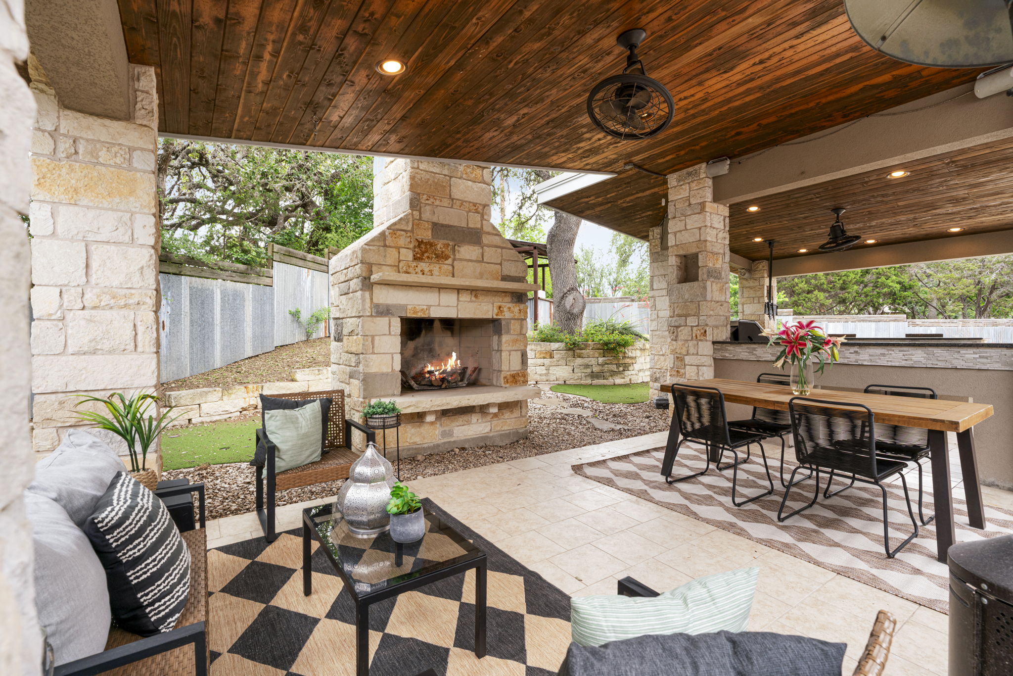 1129 Cedar Pass Road Driftwood, TX 78619 - Photo 29 of 40 Between the stunning wood ceiling, the dual ceiling fans, and that floor-to-ceiling stone fireplace, you’ll be spending every evening out here.