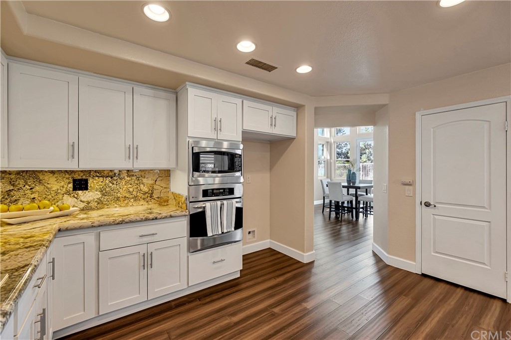 3171 Diamond View Street Corona, CA 92882 - Photo 12 of 59 a kitchen with stainless steel appliances white cabinets and wooden floors