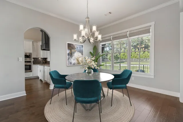 a dining room with furniture a chandelier and wooden floor