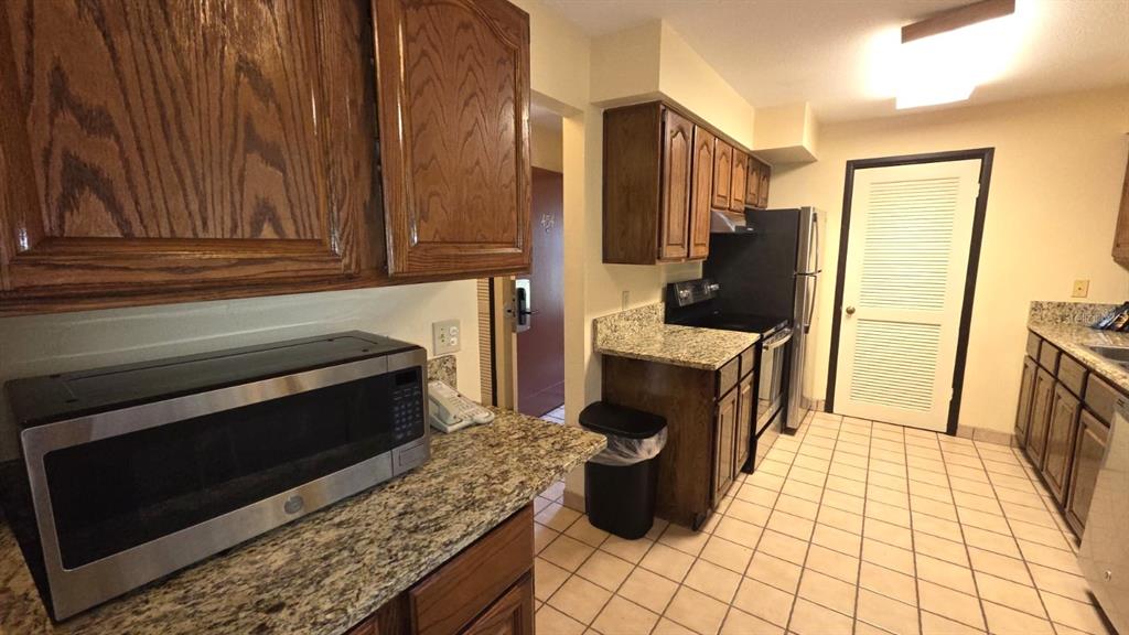 454 Cottage Circle, Unit 454 River Ranch, FL 33867 - Photo 13 of 27 a kitchen with stainless steel appliances granite countertop a stove a refrigerator and a microwave
