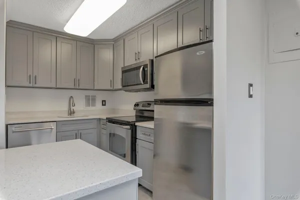 a kitchen with granite countertop a oven and cabinets