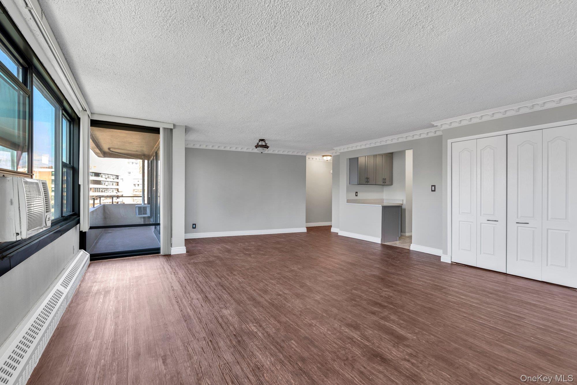 168-01 12th Avenue, Unit 7B Queens, NY 11357 - Photo 4 of 12 a view of empty room with wooden floor and window