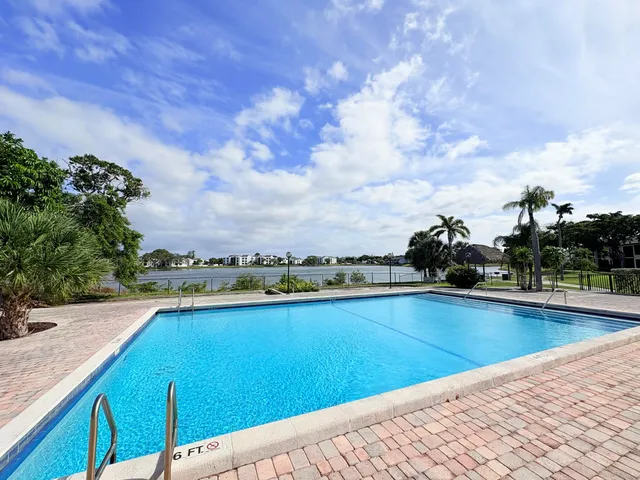 a swimming pool with outdoor seating and yard in the back