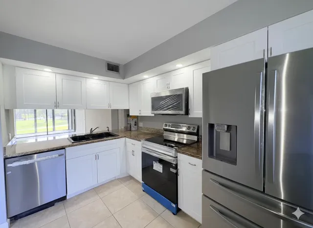 a kitchen with stainless steel appliances a refrigerator microwave and stove top oven