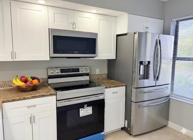a bathroom with a granite countertop sink a toilet a mirror and shower