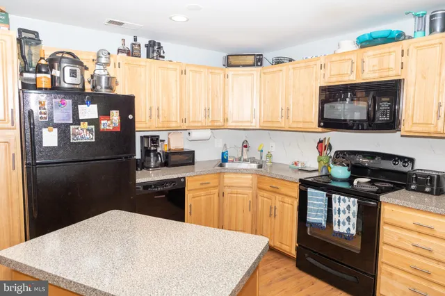 a kitchen with stainless steel appliances granite countertop a refrigerator stove top oven and sink