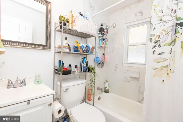 a bathroom with a sink a toilet and shower curtain