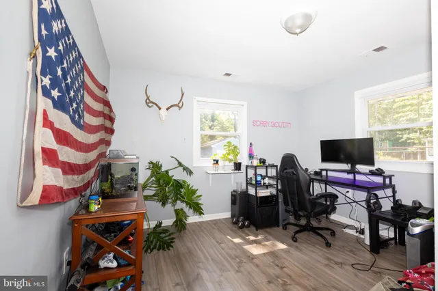 a view of a workspace with furniture and a window