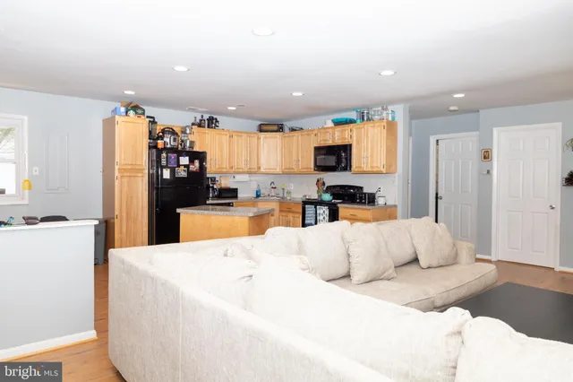 a kitchen with stainless steel appliances kitchen island granite countertop a refrigerator sink and cabinets