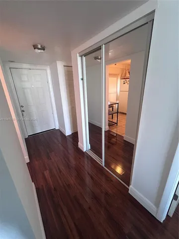 a view of front door with wooden floor and a window