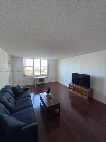 a living room with furniture a window and a flat screen tv