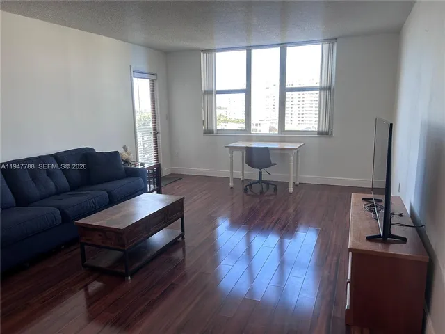 a living room with furniture a dining table and a window