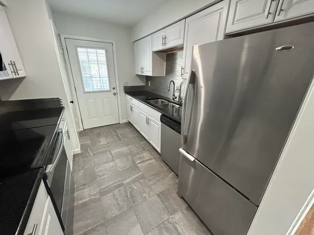 a kitchen with granite countertop a refrigerator and a stove