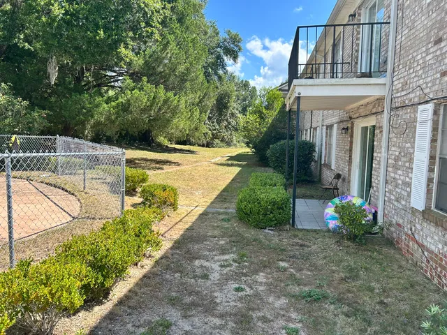 a view of a house with backyard and sitting area