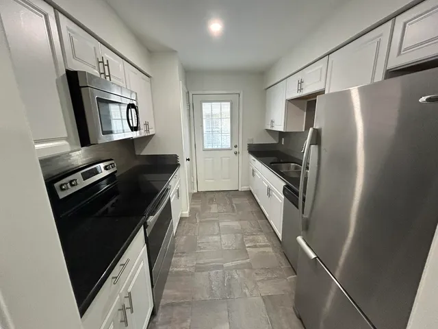 a kitchen with stainless steel appliances a refrigerator and a stove