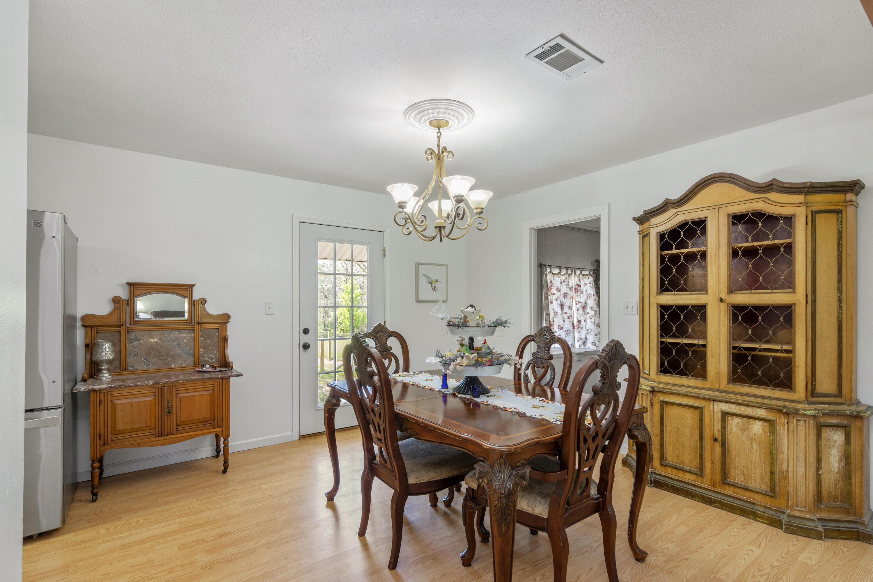 1606 Boy Scout Road DeFuniak Springs, FL 32435 - Photo 17 of 33 a view of a dining room with furniture and chandelier