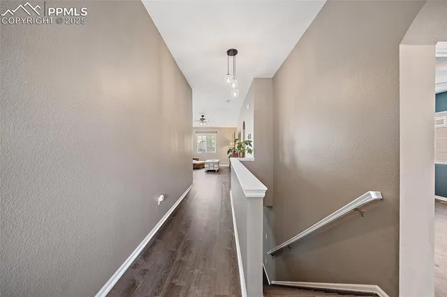 a view of a hallway with wooden floor and staircase