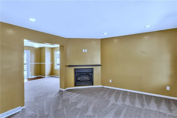 an empty room with a fireplace and a window