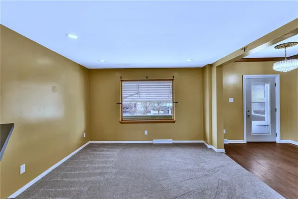 a view of a hallway with wooden floor and windows