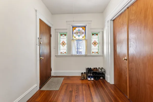 a view of a hallway with wooden floor and a window