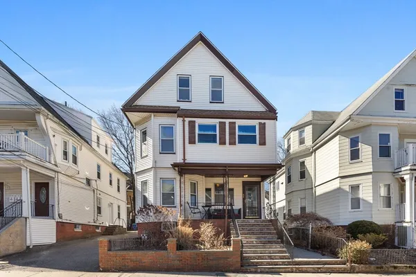a front view of a building with lot of cars parked