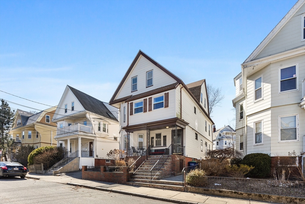 28 Pearson Road, Unit 1 Somerville, MA 02144 - Photo 17 of 18 a view of a white house with large windows next to a road