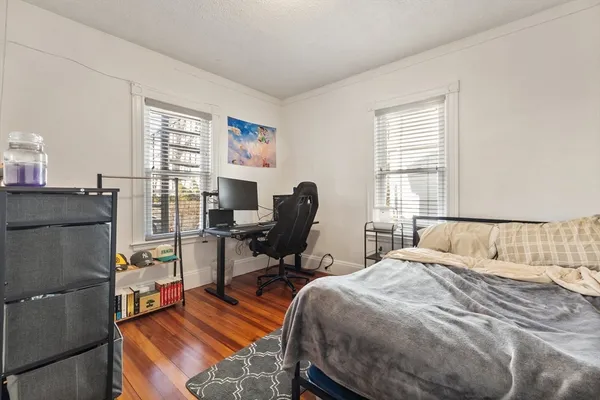 a bedroom with a bed and wooden floor