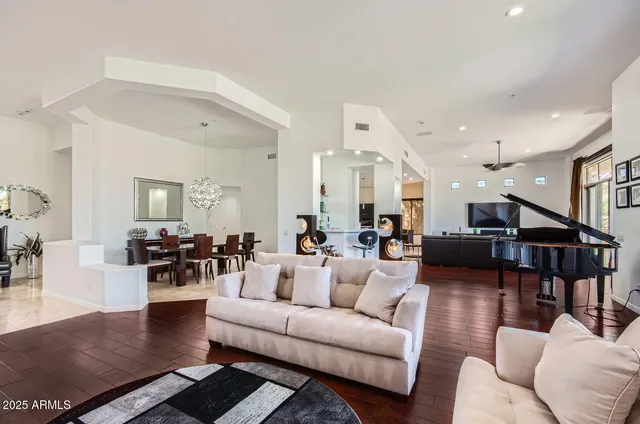 a kitchen with stainless steel appliances granite countertop dining table chairs and a refrigerator