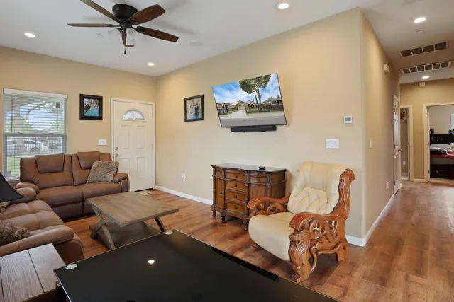a living room with furniture and a wooden floor
