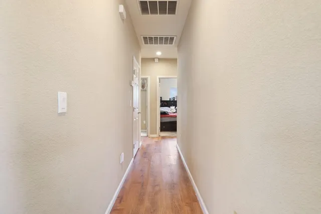 a view of a hallway with wooden floor and staircase