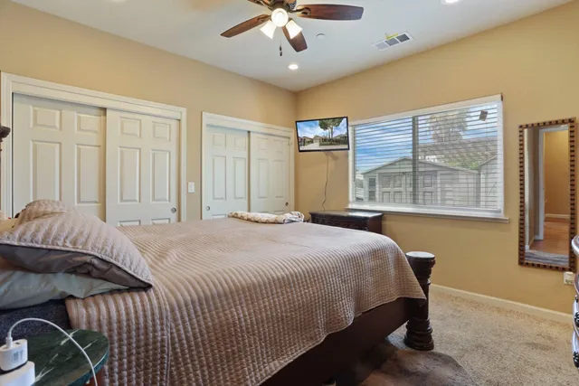 a bedroom with a large bed chandelier and a window
