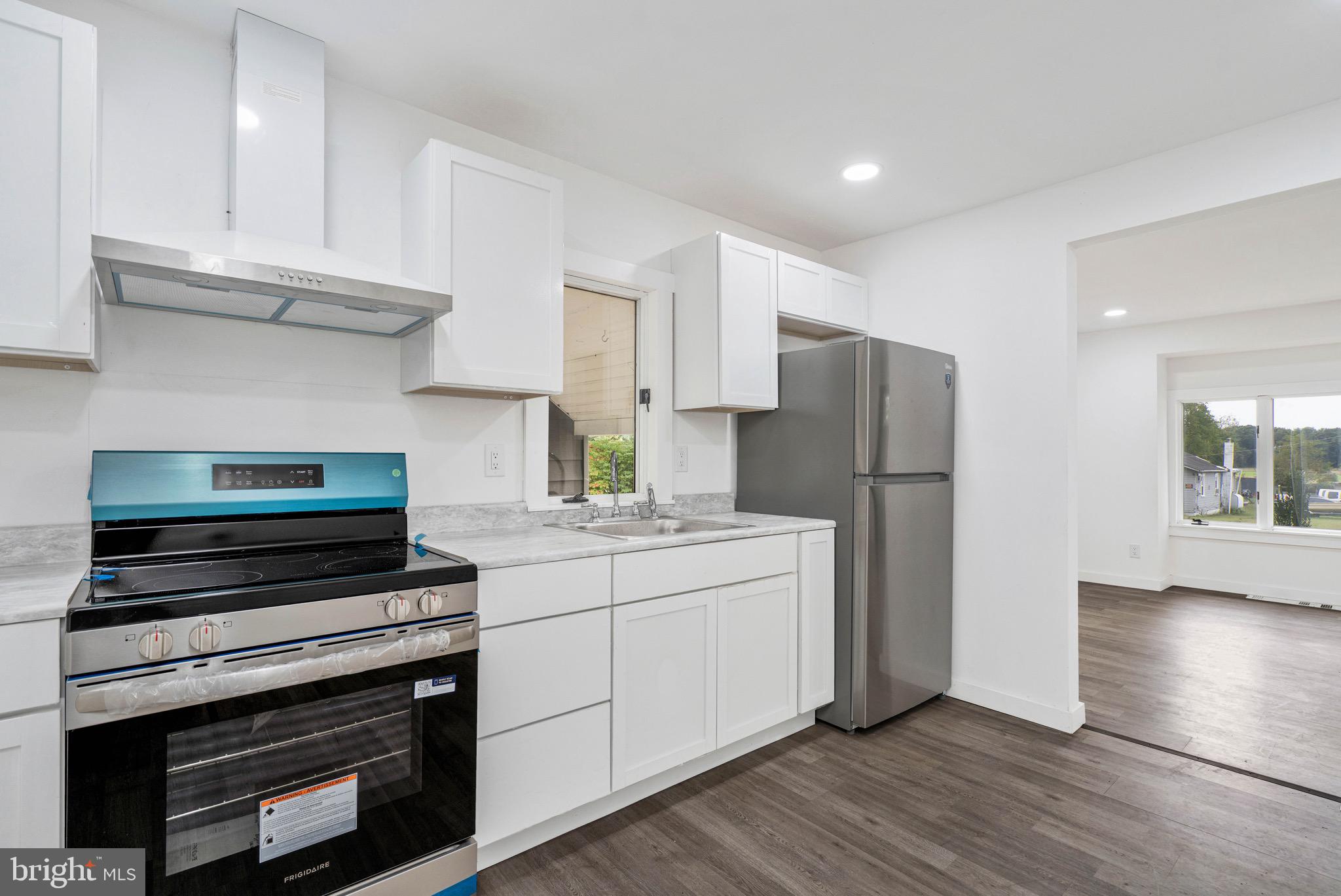 485 Lummistown Road Cedarville, NJ 08311 - Photo 12 of 34 a kitchen with a refrigerator stove and wooden cabinets