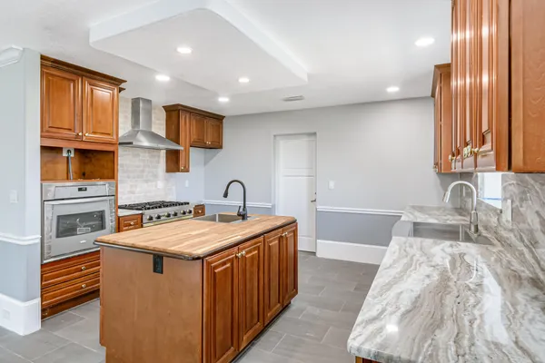 a kitchen with kitchen island granite countertop a sink window and cabinets