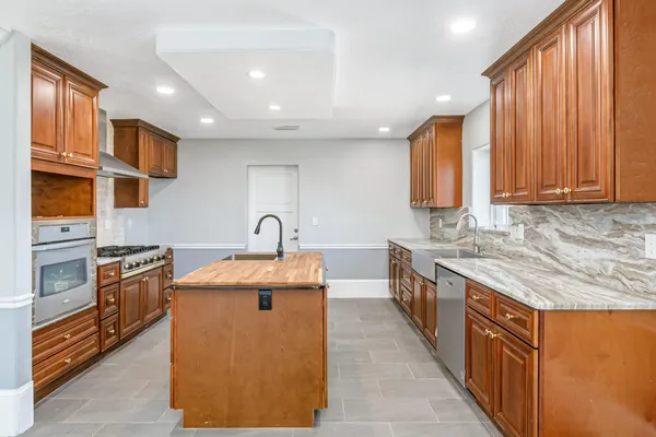 a kitchen with stainless steel appliances granite countertop a stove and a sink