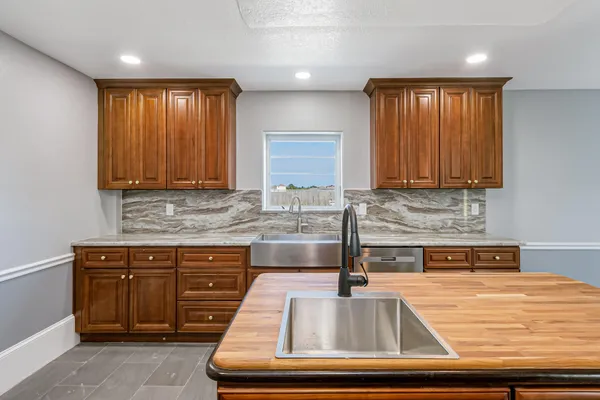 a bathroom with a granite countertop toilet sink and mirror