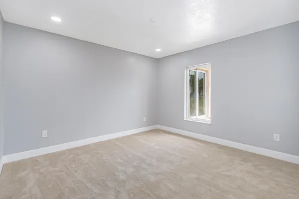 a view of an empty room with cabinet and mirrors