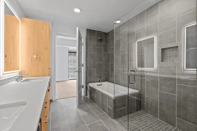 a bathroom with a tub shower and sink
