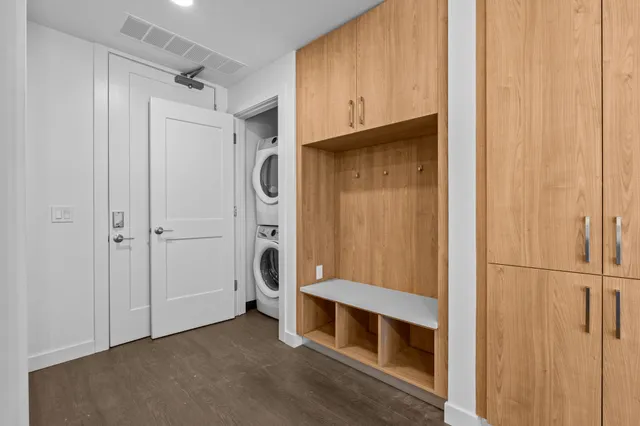 a view of an empty room with cabinet and mirrors