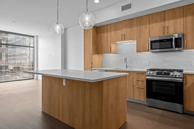 a kitchen with stainless steel appliances a stove a sink and a microwave