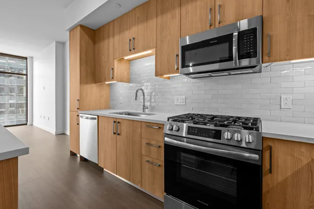 a kitchen with granite countertop cabinets stainless steel appliances and wooden floor