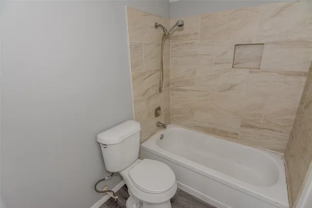 a white toilet and tub next to a bathroom sink
