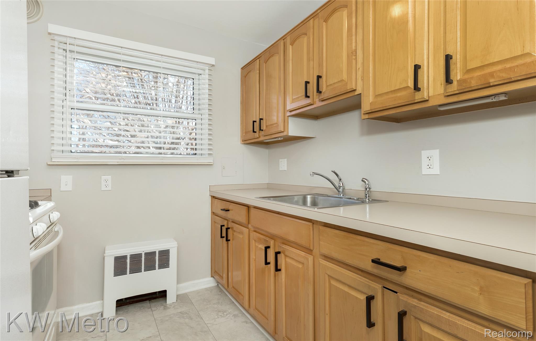 2817 West 13 Mile Road Royal Oak, MI 48073 - Photo 9 of 21 Kitchen with radiator, light countertops, white appliances, and light tile patterned floors