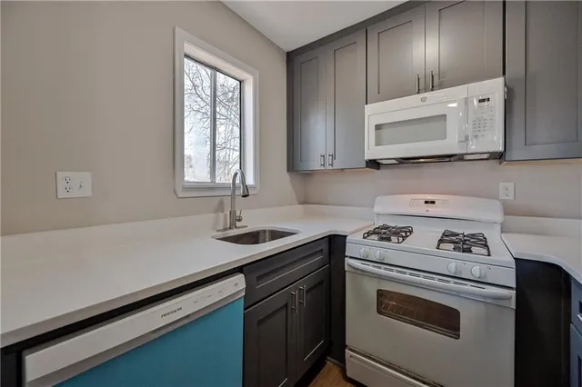a kitchen with cabinets appliances a sink and a window