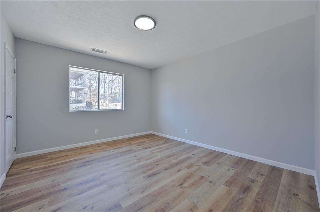 955 Tilden Street Northwest Atlanta, GA 30318 - Photo 17 of 25 an empty room with wooden floor and windows