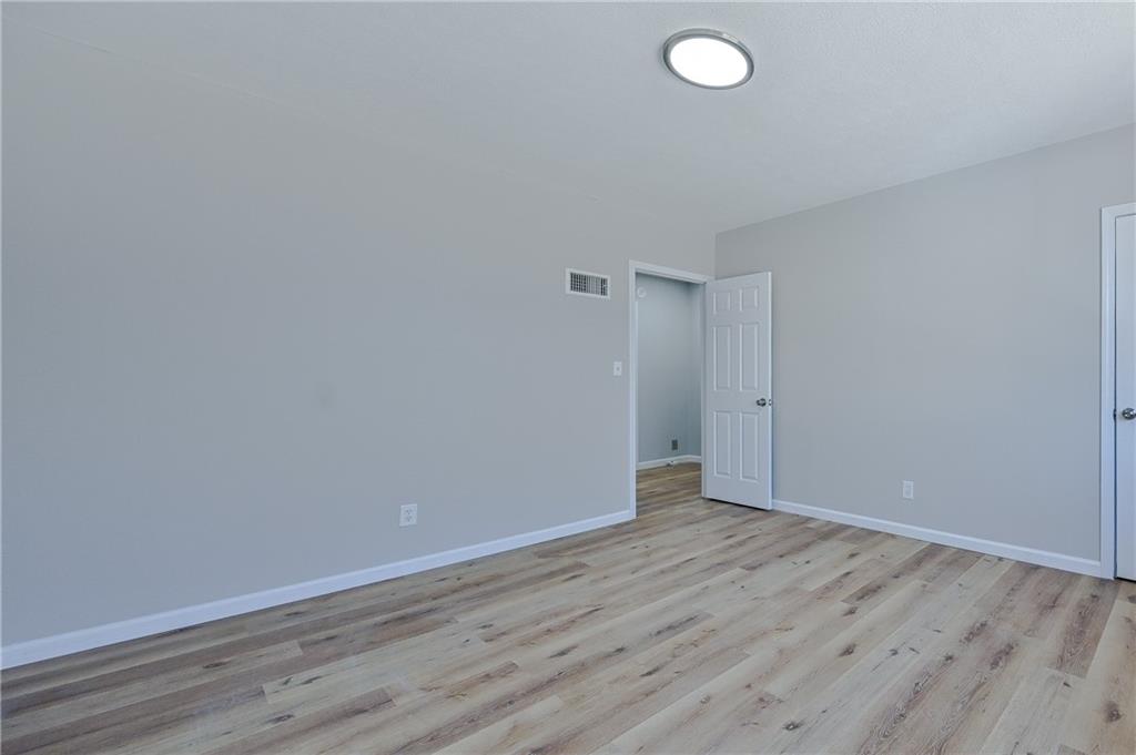 955 Tilden Street Northwest Atlanta, GA 30318 - Photo 19 of 25 a view of an empty room with wooden floor and a window