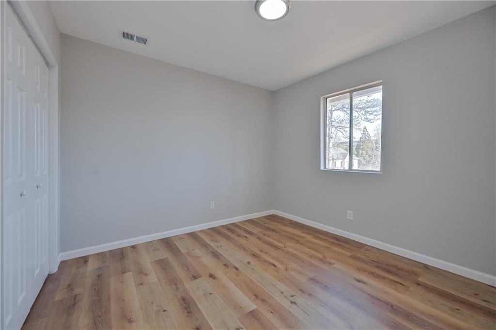 955 Tilden Street Northwest Atlanta, GA 30318 - Photo 20 of 25 an empty room with wooden floor and windows