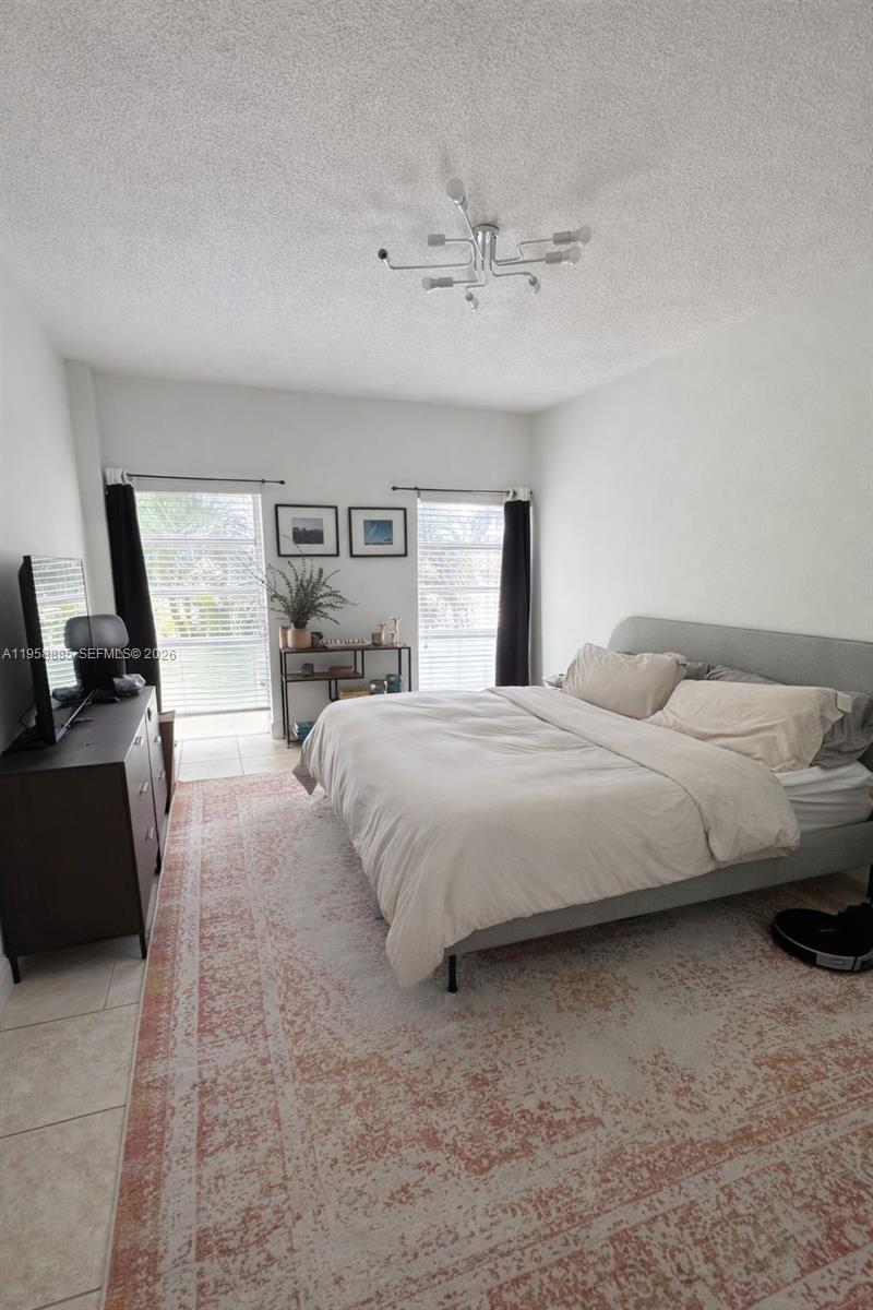 880 Northeast 69th Street, Unit 2N Miami, FL 33138 - Photo 19 of 23 a spacious bedroom with a bed and wooden floor