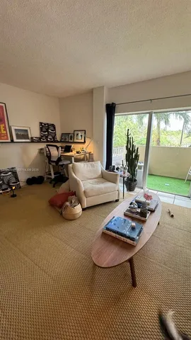 a living room with furniture a rug and a large window