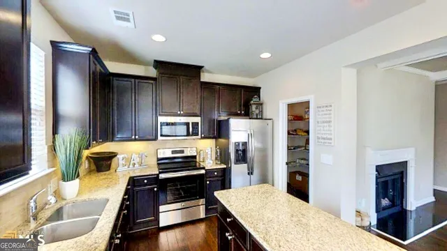 a kitchen with a refrigerator and a stove top oven